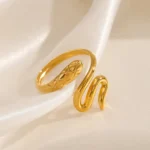 Gold-plated stainless steel snake wrap ring on satin background