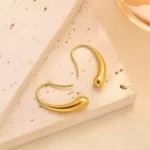 Fluid Amber Dewdrop Earrings gold drop earrings on white marble surface