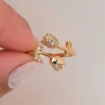 Gold-plated adjustable ring featuring two tulip flowers, one paved with clear stones and one polished, held in hand.