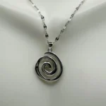 Stainless steel spiral pendant necklace in silver and gold finishes worn by a model