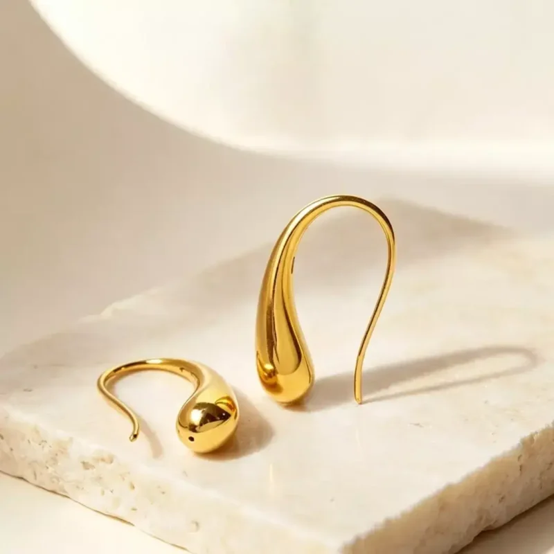 Fluid Amber Dewdrop Earrings gold drop earrings on white marble surface