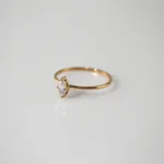 Gold plated stainless steel ring with a small marquise cut clear stone on a thin band