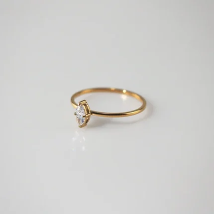 Gold plated stainless steel ring with a small marquise cut clear stone on a thin band