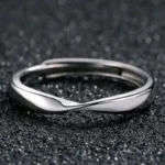Silver stainless steel twisted mobius adjustable ring on lace background