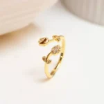 Gold-plated adjustable ring featuring two tulip flowers, one paved with clear stones and one polished, held in hand.