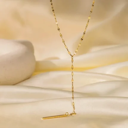Gold-plated stainless steel lariat necklace with a vertical bar pendant on a white background