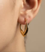 Pair of gold-plated stainless steel V-shaped hoop earrings with polished finish on a neutral background