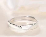 Silver stainless steel twisted mobius adjustable ring on lace background
