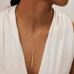 Gold-plated stainless steel lariat necklace with a vertical bar pendant on a white background