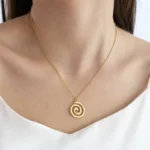 Stainless steel spiral pendant necklace in silver and gold finishes worn by a model