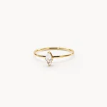 Gold plated stainless steel ring with a small marquise cut clear stone on a thin band