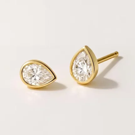 Gold-plated stainless steel teardrop bezel stud earrings with clear stones on a white background