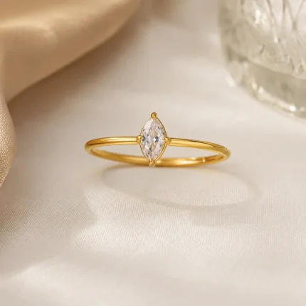Gold plated stainless steel ring with a small marquise cut clear stone on a thin band