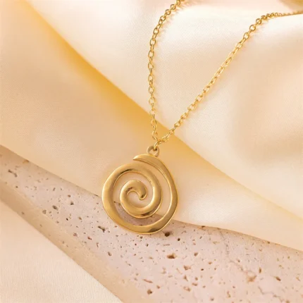 Stainless steel spiral pendant necklace in silver and gold finishes worn by a model