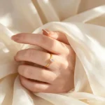 Gold plated stainless steel ring with a small marquise cut clear stone on a thin band
